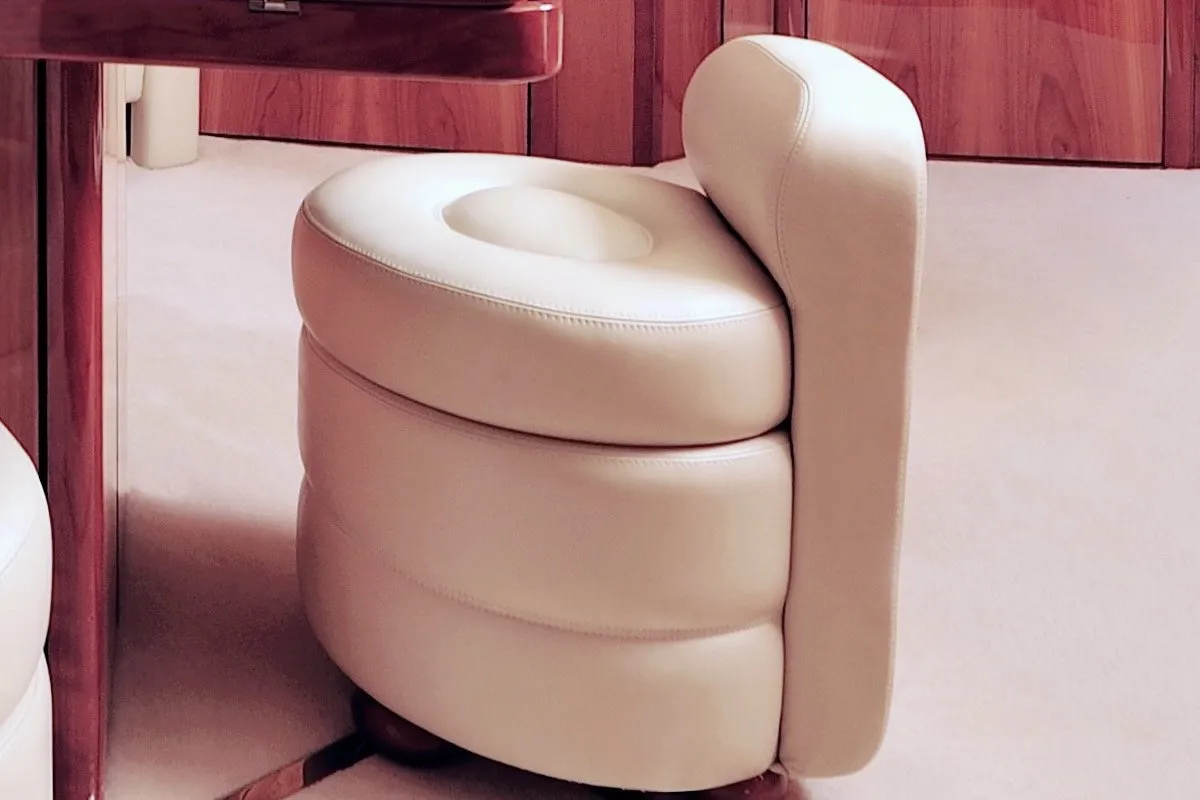 Ronde stoel bekleed met crèmekleurig leer, met stiknaden.